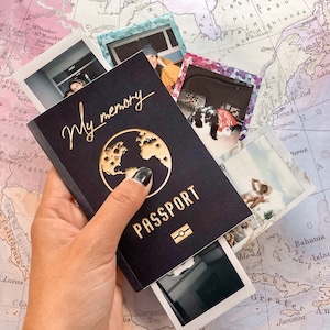 May include: A black passport cover with a gold globe design and the words "My memory PASSPORT" in gold lettering.