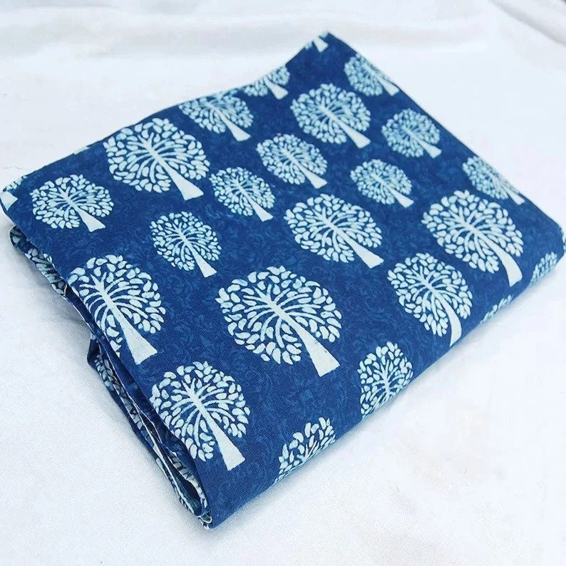 Puede incluir: Un trozo de tela azul doblado con un patr&oacute;n de &aacute;rbol blanco. La tela tiene una superficie texturizada y es perfecta para proyectos de artesan&iacute;a o costura.