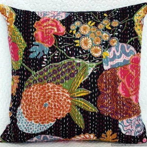 May include: A black cotton cushion cover with a floral pattern in shades of pink, orange, green, and blue. The fabric is quilted with white stitching.