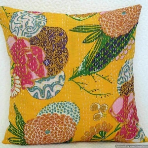 May include: Yellow cotton cushion cover with a floral pattern in shades of pink, green, brown, and blue. The pattern features large flowers, leaves, and swirls.