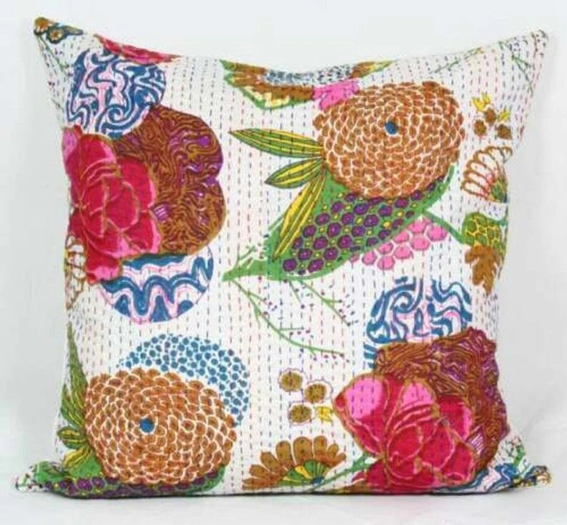 May include: A white cotton pillow cover with a colorful floral pattern. The pattern features pink, green, blue, and brown flowers and leaves. The pillow cover is quilted and has a subtle sheen.