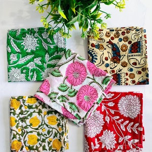 May include: Set of five cotton napkins with floral patterns. The napkins are in green, pink, yellow, red, and beige with white floral designs.