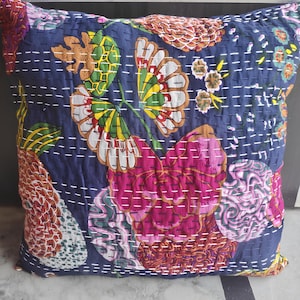 May include: A blue cotton pillow cover with a floral pattern in shades of pink, red, green, and yellow. The pillow cover is quilted with white thread and has a decorative stitch around the edges.
