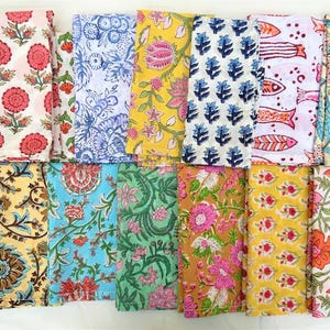 Pode incluir: Uma coleção de guardanapos de tecido dobrados com vários desenhos florais e estampados. Os guardanapos apresentam uma variedade de cores, incluindo rosa, vermelho, azul, amarelo e verde. Cada guardanapo mostra uma impressão única, criando uma exibição diversificada e colorida.