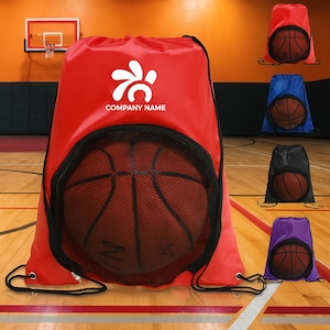May include: Red drawstring bag with a basketball visible through a black mesh pocket. The bag has a white logo and the text "COMPANY NAME". Additional bags in blue, black, and purple are also shown, each with a basketball.
