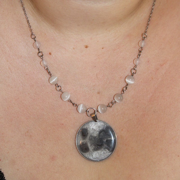 Collier avec un pendentif lunaire et ses petites perles d'œil de chat blanches.