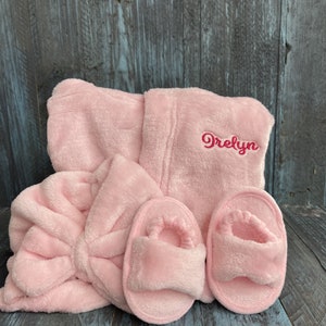 Peut inclure: Un ensemble de spa en peluche rose clair comprenant un peignoir, un bandeau et une paire de pantoufles. Le peignoir est brod&eacute; du nom "Orelyn" en fil rose assorti. L'ensemble est en mati&egrave;re douce et duveteuse.