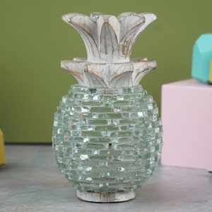 May include: A white wooden pineapple shaped candle holder with a green glass mosaic body.