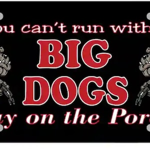 Puede incluir: Placa de matrícula negra y roja con un dicho humorístico: "Si no puedes correr con los GRANDES PERROS, quédate en el porche!" Dos bulldogs de dibujos animados con cadenas a cada lado del texto.