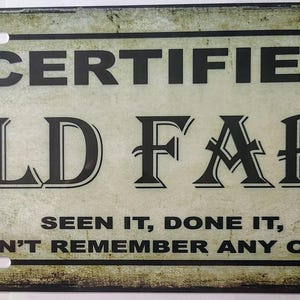 May include: Rectangular metal sign with the words "CERTIFIED OLD FART" in bold black letters. The sign also includes the phrases "SEEN IT, DONE IT, CAN'T REMEMBER ANY OF IT!" The background has a distressed, vintage look.
