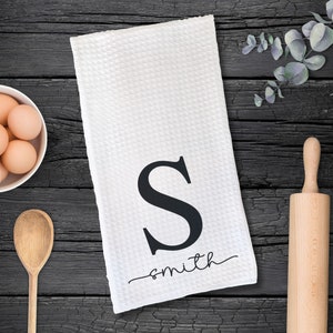 May include: White kitchen towel with a black letter S and the word "smith" in cursive script.