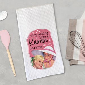 May include: White kitchen towel with a pink and white illustration of two women wearing hats. The text on the towel reads "stop acting like a Karen darling".