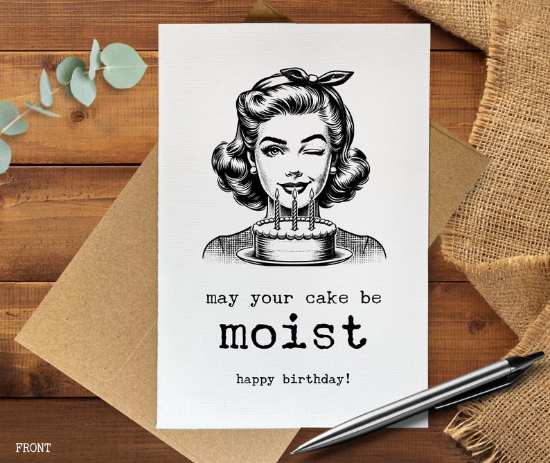 May include: A black and white birthday card featuring a vintage illustration of a woman winking and holding a cake with lit candles. The card reads "may your cake be moist" and "happy birthday!"