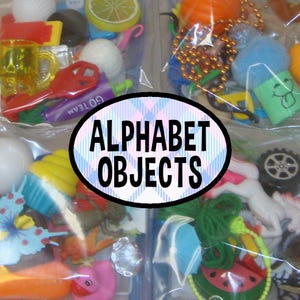 May include: A collection of assorted miniature plastic toys and objects packaged in clear plastic bags, featuring a variety of shapes, colors, and textures. A central oval label with a blue plaid background displays the text ALPHABET OBJECTS.