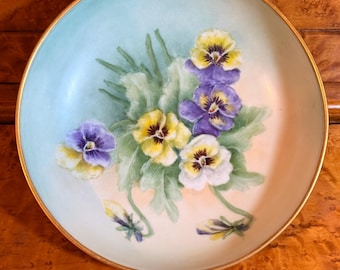 Bol antiguo de Limoges T & V Francia con base dorada, pintado a mano con violetas africanas y firmado.