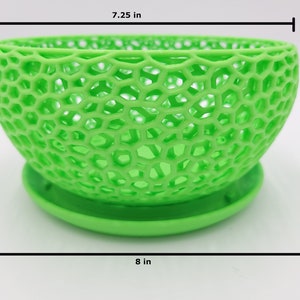 May include: A green, 3D printed, geometric planter with a 7.25 inch diameter and 4 inch height. The planter has a saucer base and is 8 inches wide.