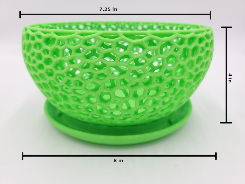 May include: A green, 3D printed, geometric planter with a 7.25 inch diameter and 4 inch height. The planter has a saucer base and is 8 inches wide.