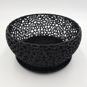 May include: A black, 3D printed bowl with a geometric, honeycomb-like design. The bowl has a solid base and is perfect for holding small items.