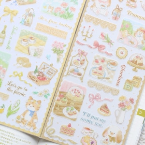 Puede incluir: Dos hojas de pegatinas decorativas con ilustraciones en acuarela de escenas de picnic, fiestas de té, pasteles, repostería, cintas y animales pequeños. El texto incluye frases como It's fine today, Take a walk, Let's go to the picnic, Tranquil time, Glorious e I'll put up some tea.