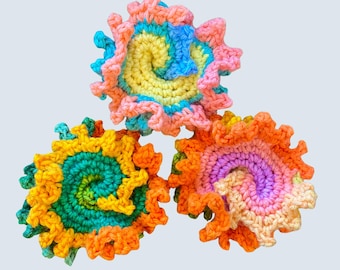 May include: Three colorful, handmade crochet spiral designs. Each spiral features a unique combination of bright colors, including yellow, orange, pink, blue, and green. The edges are scalloped, adding a textured, decorative element to the craft.
