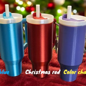 May include: Three travel mugs with lids and straws. The mugs are ice blue, Christmas red, and color change.