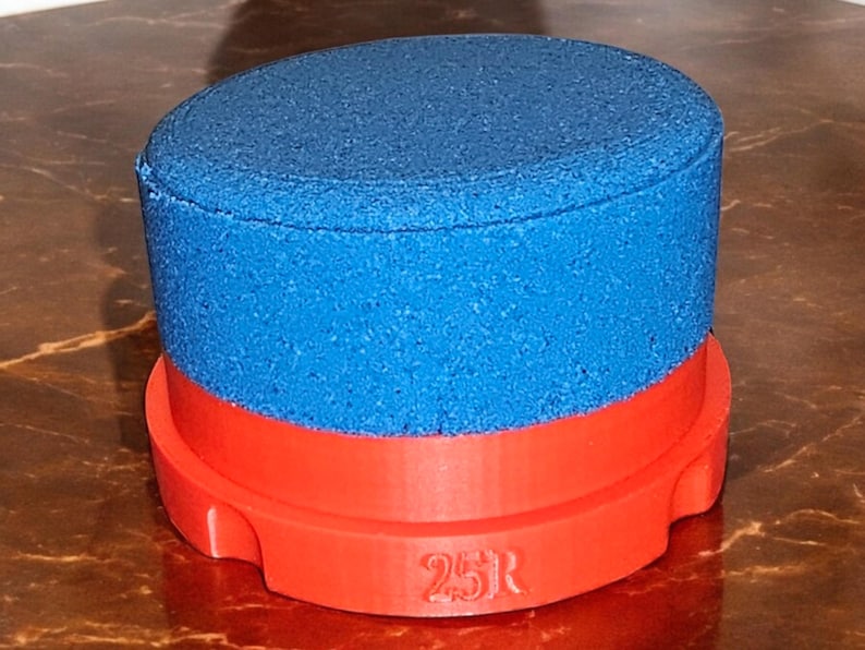 May include: A blue and red cylindrical object with a textured surface and the number "25R" printed on the bottom.