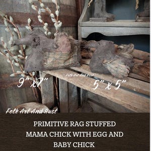 Puede incluir: Dos figuras primitivas de mamá y pollito rellenas de trapos. La mamá mide aproximadamente 23 cm x 18 cm y el pollito mide aproximadamente 13 cm x 13 cm. Las figuras están hechas de tela marrón con detalles en beige y crema. El texto "Folk Art And Rust" y "PRIMITIVE RAG STUFFED MAMA CHICK WITH EGG AND BABY CHICK" son visibles.