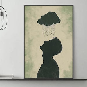 May include: A framed art print featuring a silhouette of a person looking up at a dark cloud with rain. The artwork has a neutral color palette with a green and beige background.