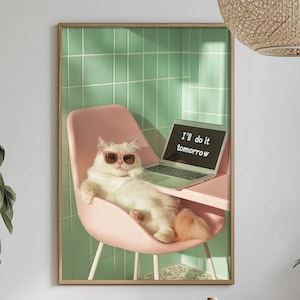 Pode incluir: Impressão emoldurada com um gato branco usando óculos de sol rosa, relaxando em uma cadeira rosa com um laptop. A tela do laptop exibe o texto "I'll do it tomorrow". O fundo tem um padrão de azulejos verdes.