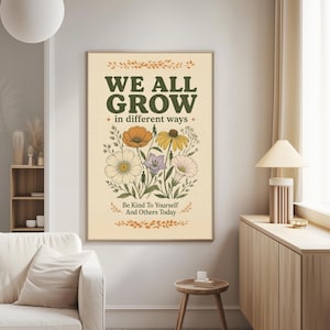 a poster with a floral design and the text "We all grow in different ways" hanging on a wall in a living room.