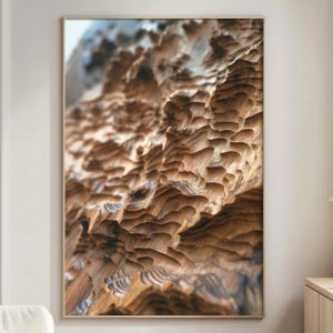 May include: A framed abstract art print featuring a close-up of carved wood. The artwork showcases a detailed texture with varying shades of brown and tan, creating a sense of depth and dimension. The wood grain is visible, adding to the natural aesthetic.