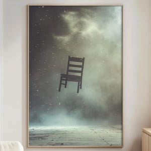 May include: A framed art print featuring a dark wooden chair floating in a misty, atmospheric scene. The chair is silhouetted against a backdrop of swirling fog and particles, creating a surreal and dreamlike composition. The artwork is set in a room with a concrete floor.