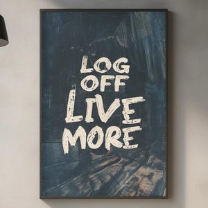 May include: A framed art print with the words "LOG OFF LIVE MORE" in a white, brushstroke font. The background is a dark blue with textured brush marks, creating a modern, motivational piece.
