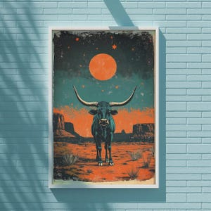 May include: A framed art print featuring a stylized illustration of a longhorn bull in a desert landscape. The artwork has a vintage aesthetic, with a color palette of teal, orange, and brown. The bull stands beneath a large orange sun and a starry night sky.