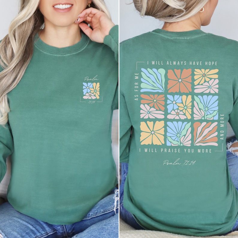 K&ouml;nnte beinhalten: Ein gr&uuml;nes Langarmshirt mit einem Blumendesign und dem Text "Psalm 71:14" auf der Vorder- und R&uuml;ckseite. Das Design auf der R&uuml;ckseite zeigt ein Raster aus bunten Blumen mit dem Text "Was mich betrifft, so werde ich immer Hoffnung haben. Ich werde dich mehr und mehr preisen."