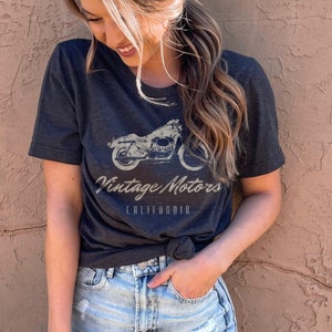 May include: A dark gray t-shirt with a vintage motorcycle graphic and the text "Vintage Motors California".