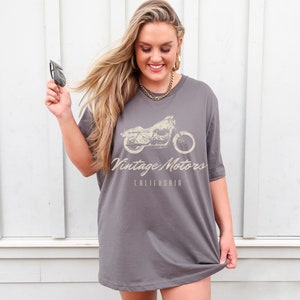 May include: A gray oversized t-shirt with a vintage motorcycle graphic and the text "Vintage Motors California".