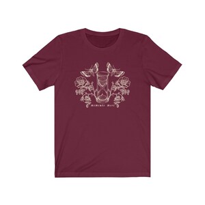 May include: A maroon t-shirt with a white graphic design of an hourglass, butterflies, and flowers. The text "Memento Mori" is printed below the hourglass.