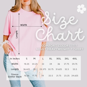 Op de afbeelding: Een lichtroze Comfort Colors 1717 volwassen heavyweight t-shirt met een maattabel. De tabel toont afmetingen in inches voor breedte, lengte en mouw midden achter voor maten S t/m 4XL.