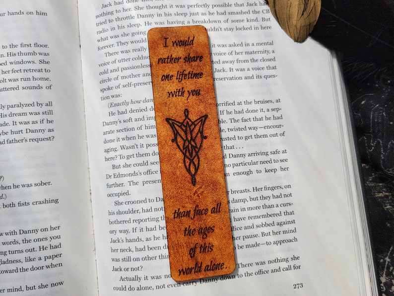 May include: A brown leather bookmark with a Celtic knot design and the quote "I would rather share one lifetime with you than face all the ages of this world alone."