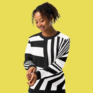 K&ouml;nnte beinhalten: Schwarz-wei&szlig;er Pullover mit geometrischem Muster. Das Design zeigt gro&szlig;e rechteckige und gestreifte Elemente. Der lang&auml;rmlige Pullover ist aus weichem Material gefertigt und eignet sich f&uuml;r Freizeitkleidung. Ein vielseitiges Kleidungsst&uuml;ck.