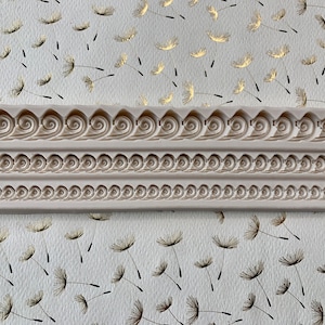 May include: A white silicone mold with three rows of decorative patterns. The mold is designed for creating cake borders or other edible decorations.