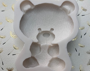 May include: White silicone mold shaped like a teddy bear with a textured surface. The mold is designed for making edible treats.