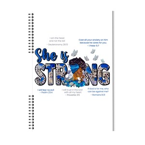 May include: A spiral-bound notebook with a vibrant design. The cover features the words "She is Strong" in blue and leopard print, with an illustration of a woman and inspirational quotes. The design includes butterflies and floral accents.