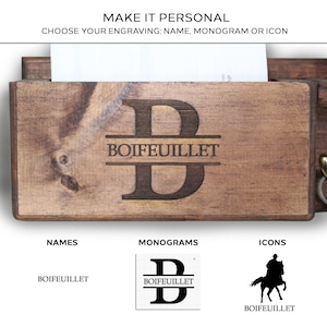 Pu&ograve; includere: Un organizer da parete in legno con il nome "BOIFEUILLET" inciso e un grande monogramma della lettera "B". Il testo "MAKE IT PERSONAL" e "CHOOSE YOUR ENGRAVING: NAME, MONOGRAM OR ICON" sono in alto. Sotto sono mostrati esempi di nomi, monogrammi e icone.