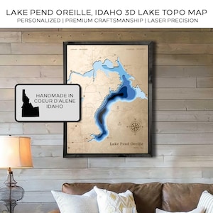 May include: A framed 3D topographic map of Lake Pend Oreille, Idaho, with varying shades of blue representing water depth. The map is laser-cut and personalized, with the text "Lake Pend Oreille" and "Handmade in Coeur d'Alene Idaho" visible.