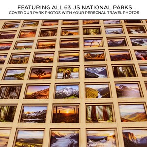 Op de afbeelding: Een houten display met 63 Amerikaanse nationale parken. Elk park heeft een foto en de display bevat de tekst "FEATURING ALL 63 US NATIONAL PARKS COVER OUR PARK PHOTOS WITH YOUR PERSONAL TRAVEL PHOTOS". De display is ontworpen om persoonlijke reisfoto's te bevatten.
