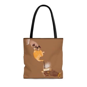 Puede incluir: Bolso tote marrón con asas negras. Presenta una ilustración de una tetera vertiendo té en una taza. La ilustración incluye manos adornadas con joyas y henna, sobre un fondo marrón. El bolso está diseñado para transportar objetos.