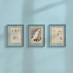 Può includere: Tre stampe incorniciate con cornici blu e passe-partout a scacchi verdi e bianchi. Le stampe presentano illustrazioni, tra cui una con il testo "ABC de Babar". Le stampe sono esposte su una parete azzurra.