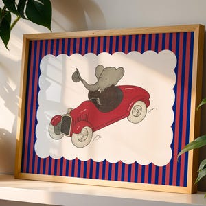 May include: Framed art print featuring a cartoon elephant driving a red vintage car. The artwork is set against a white background with a scalloped edge, framed by a striped pattern of red and blue, and a natural wood frame.